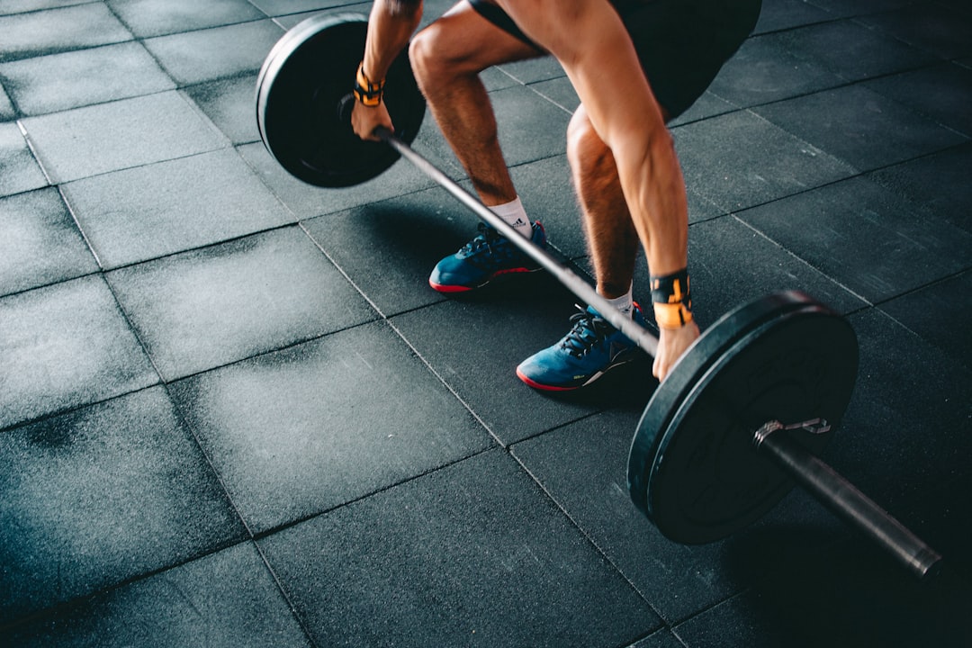 Athlète effectuant un soulevé de terre avec une barbell chargée sur le plateau de musculation